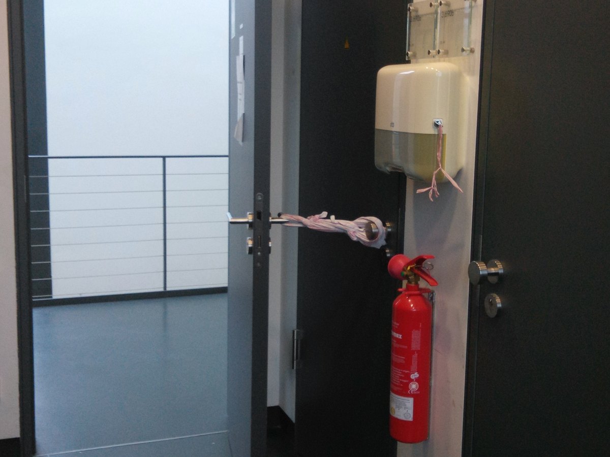Feuerschutztür, mit einer Schnur am Türgriff offen gehalten